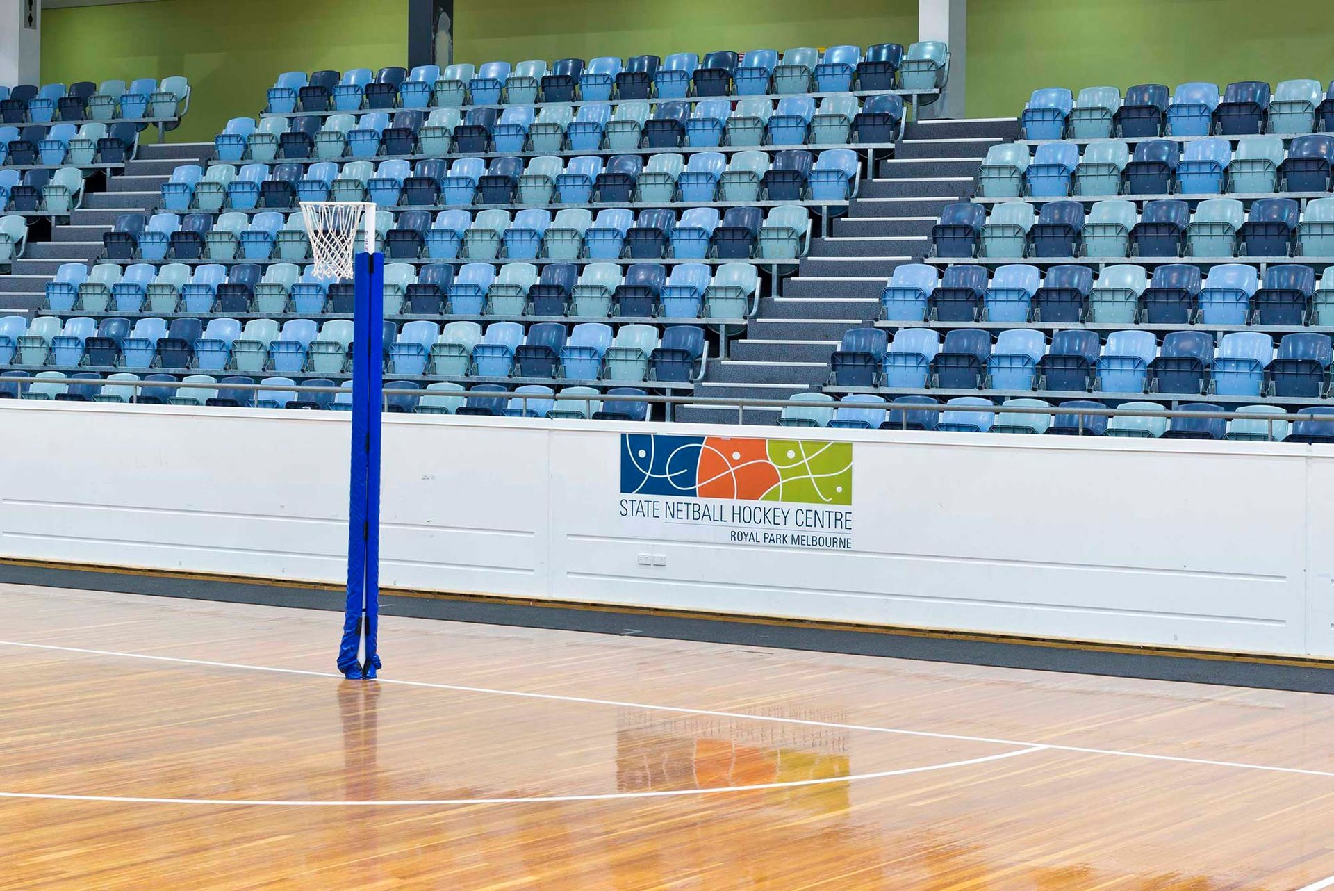 An empty basketball court with bleachers in the background