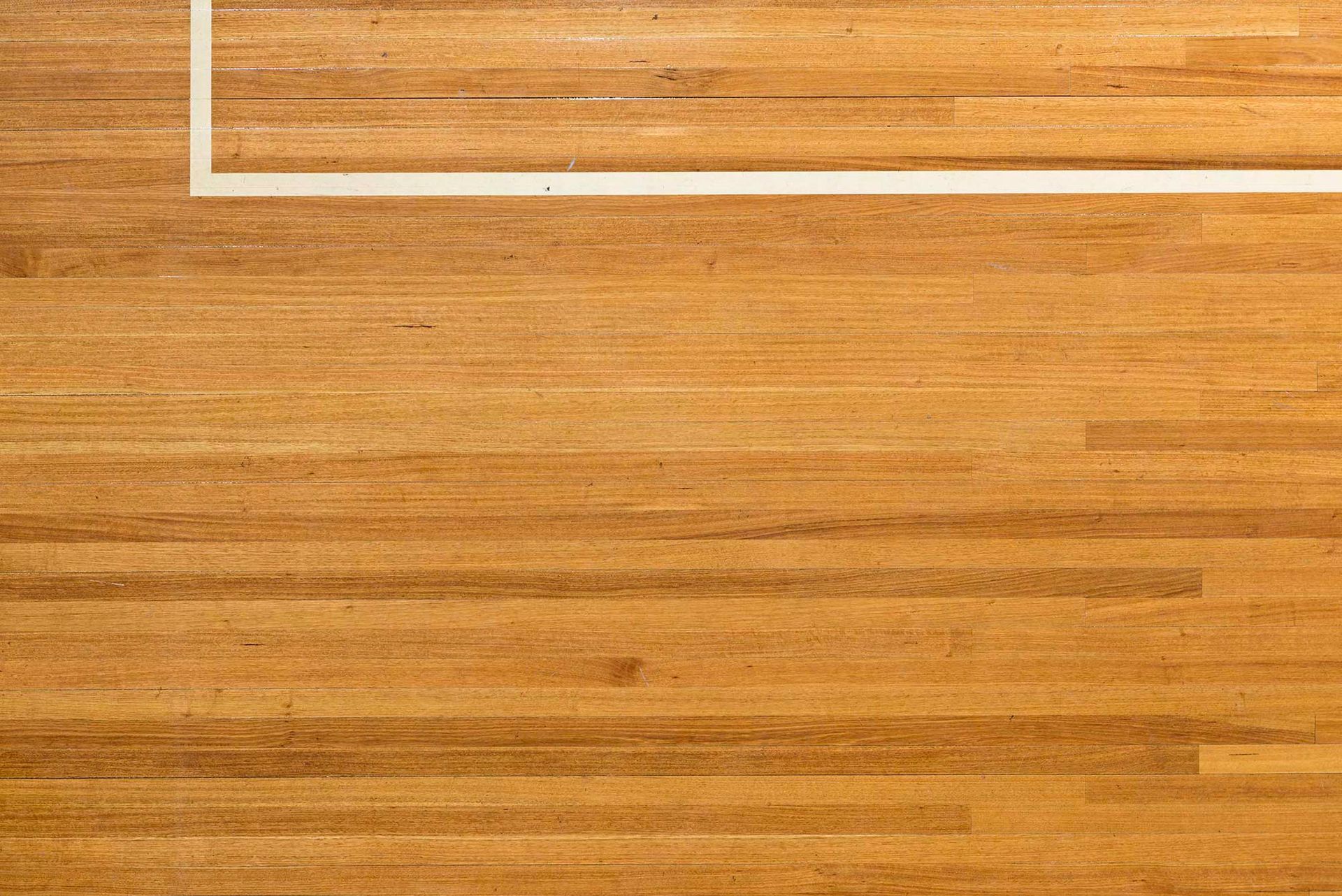 A wooden floor with a white line on it.