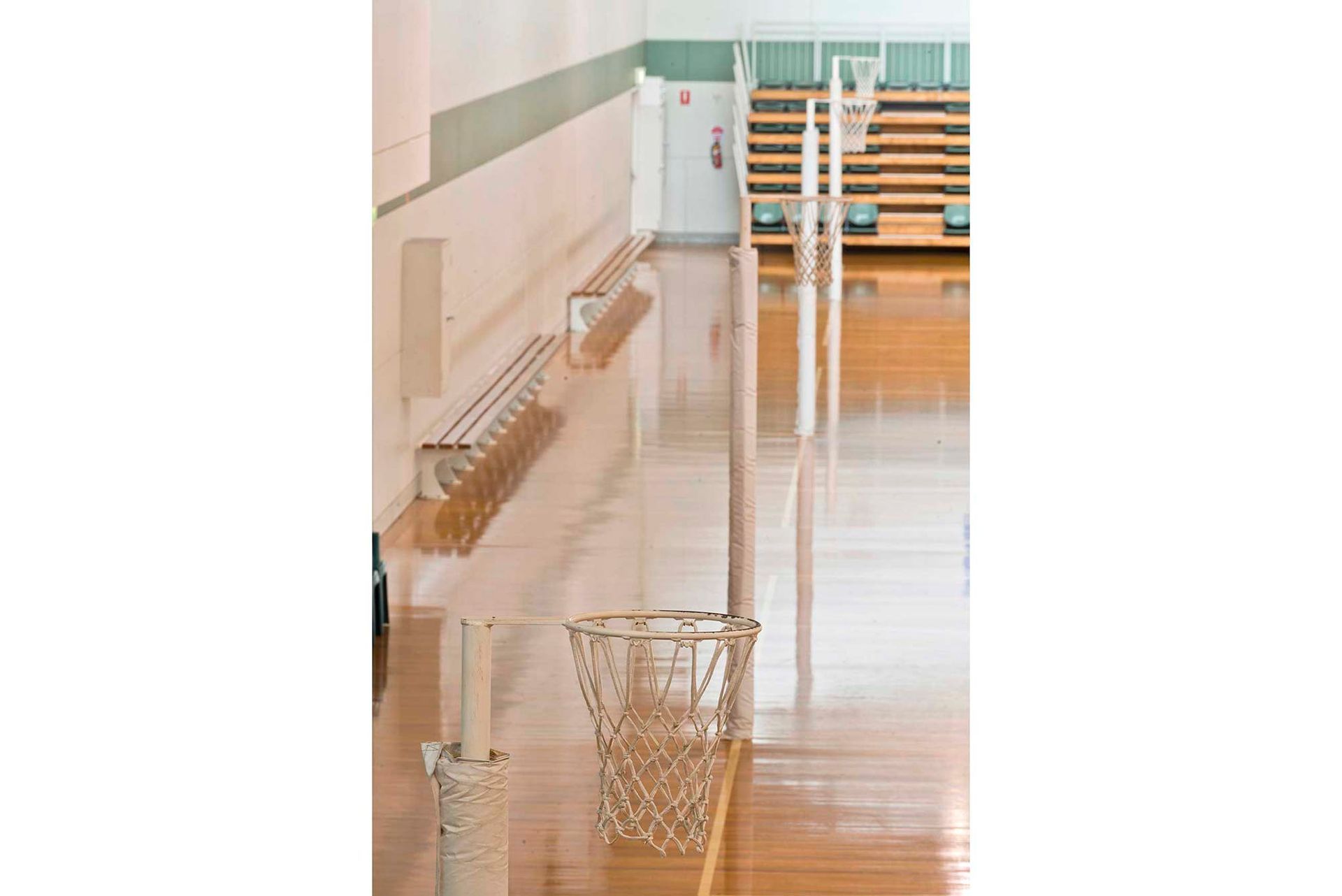 A basketball hoop is sitting on a wooden floor in a gym.