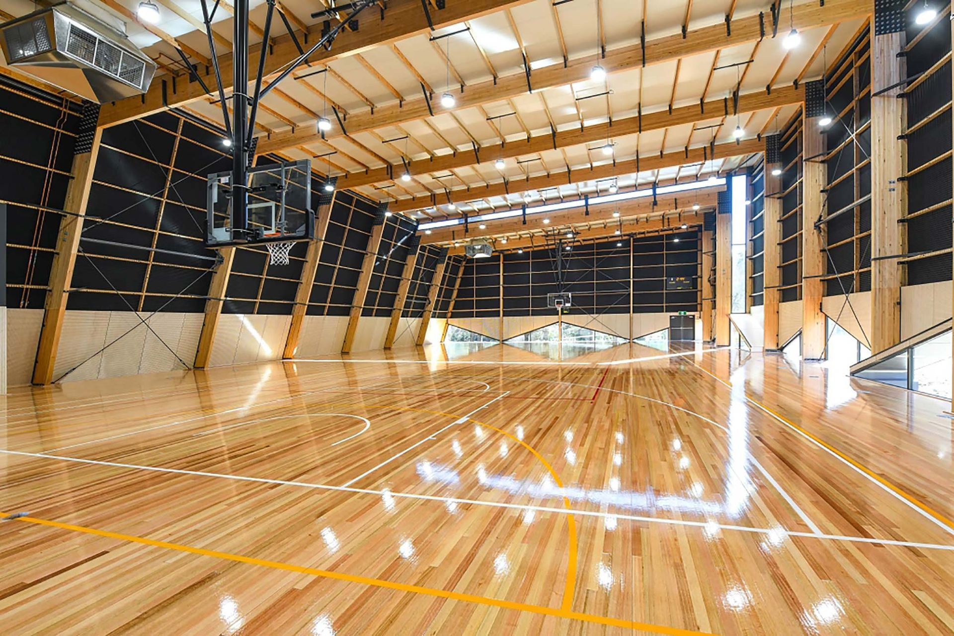 A large indoor basketball court with a wooden floor