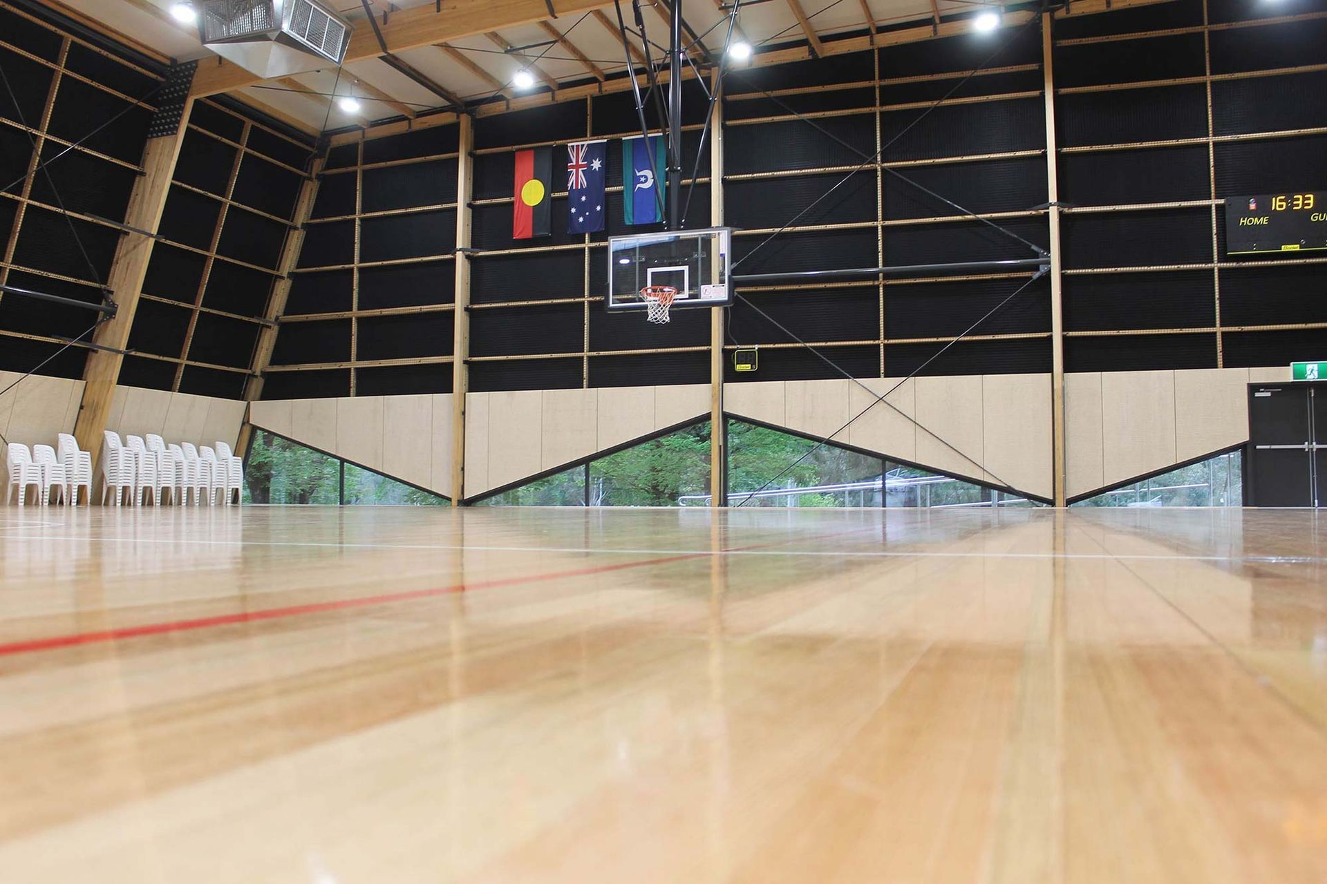 A basketball court with a wooden floor and a basketball hoop
