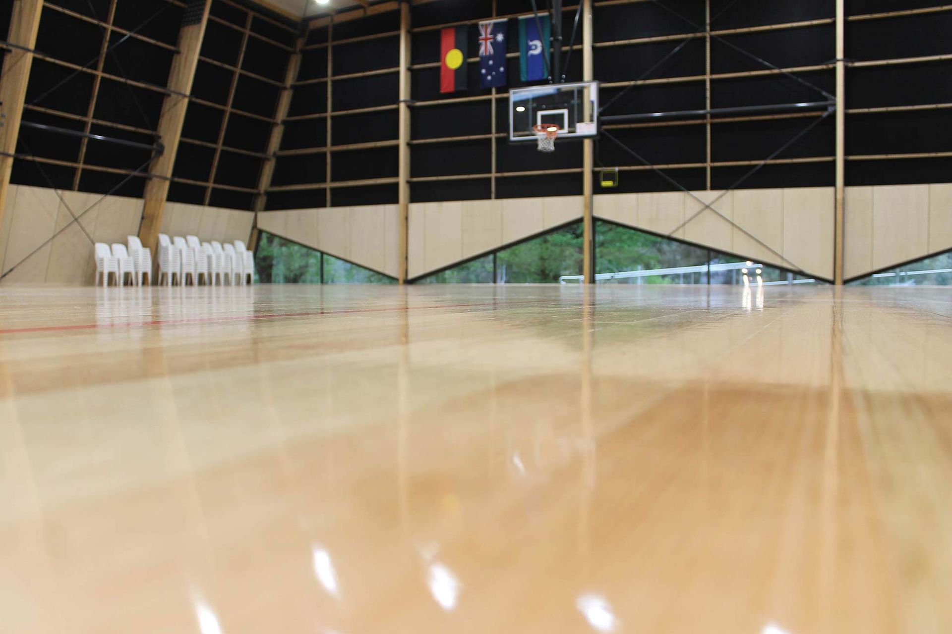 A basketball court with a wooden floor and a basketball hoop.