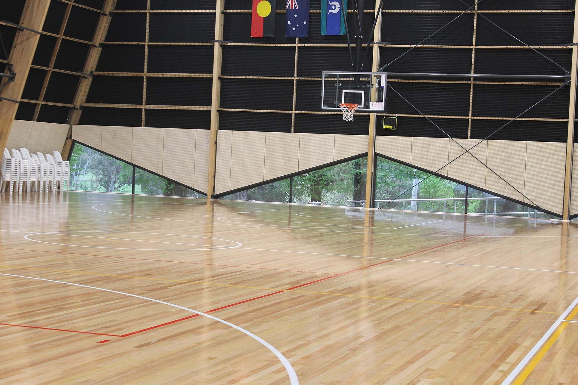 A basketball court with a wooden floor and a basketball hoop