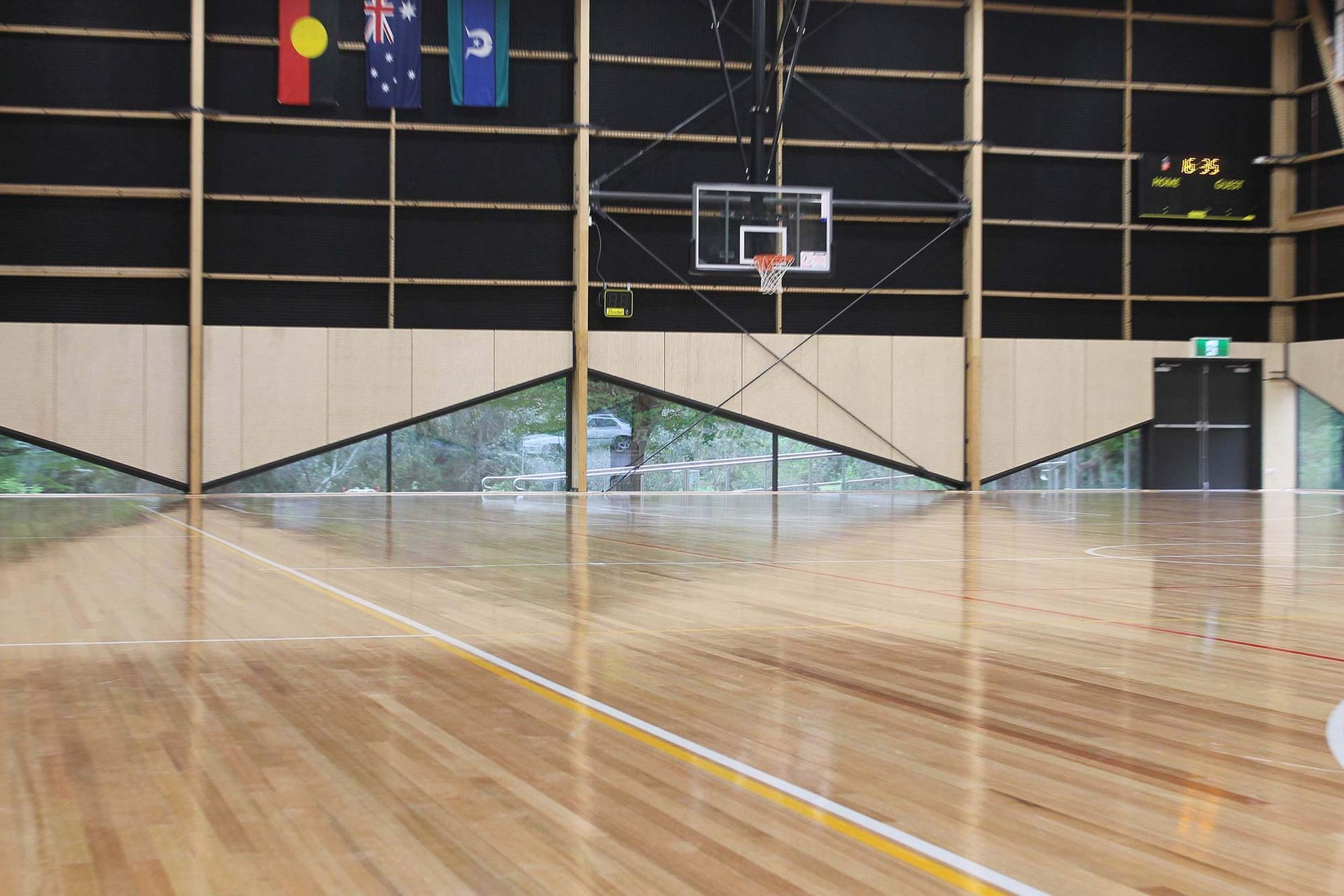 A basketball court with a wooden floor and a basketball hoop