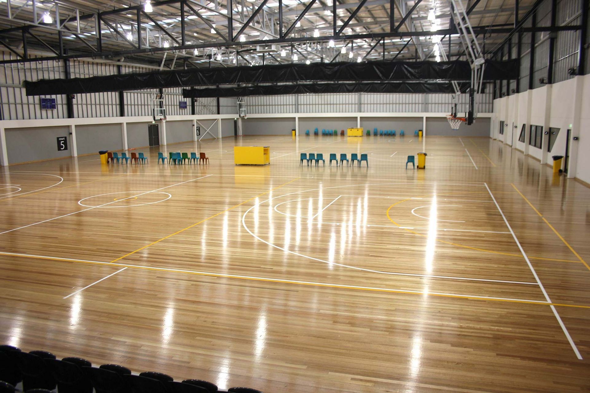 A large indoor basketball court with a wooden floor