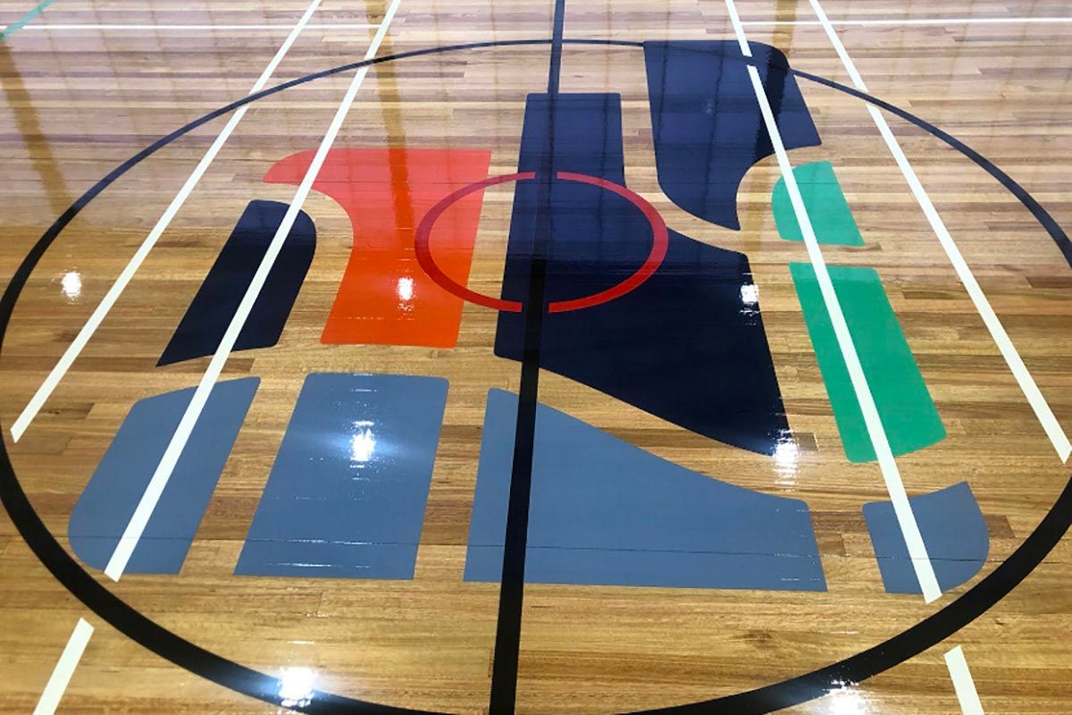 A basketball court with a logo painted on the floor