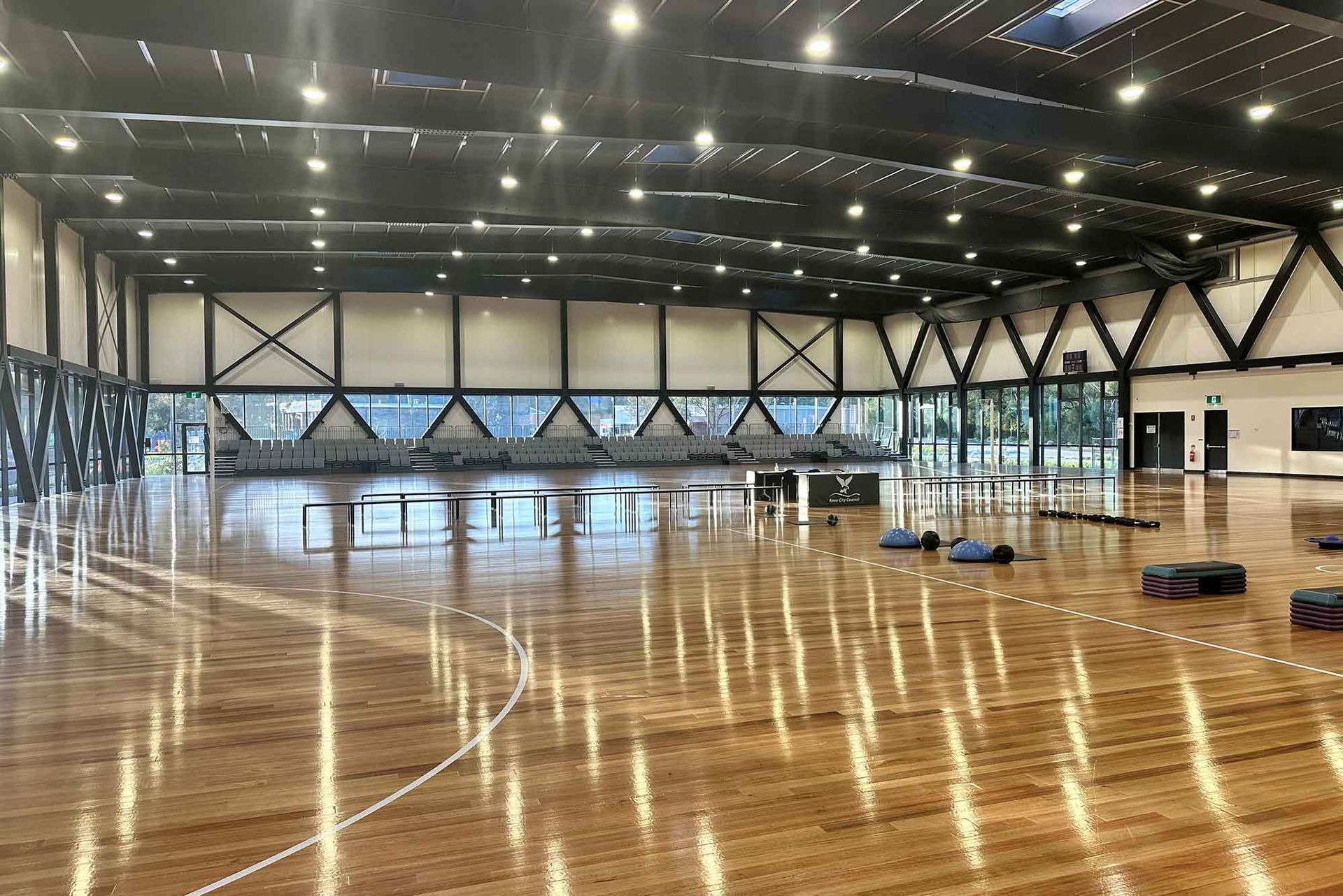 A large empty gym with a wooden floor and a basketball court.