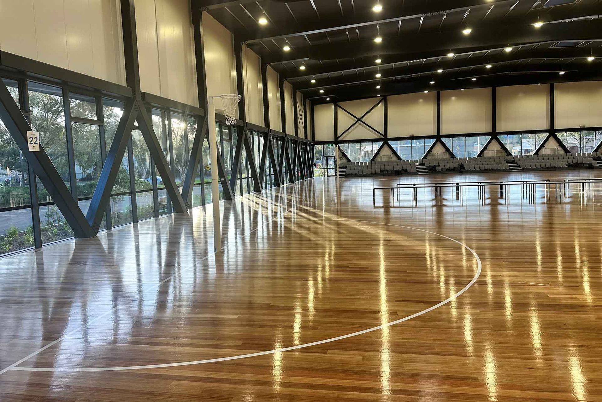 A large indoor basketball court with a wooden floor.