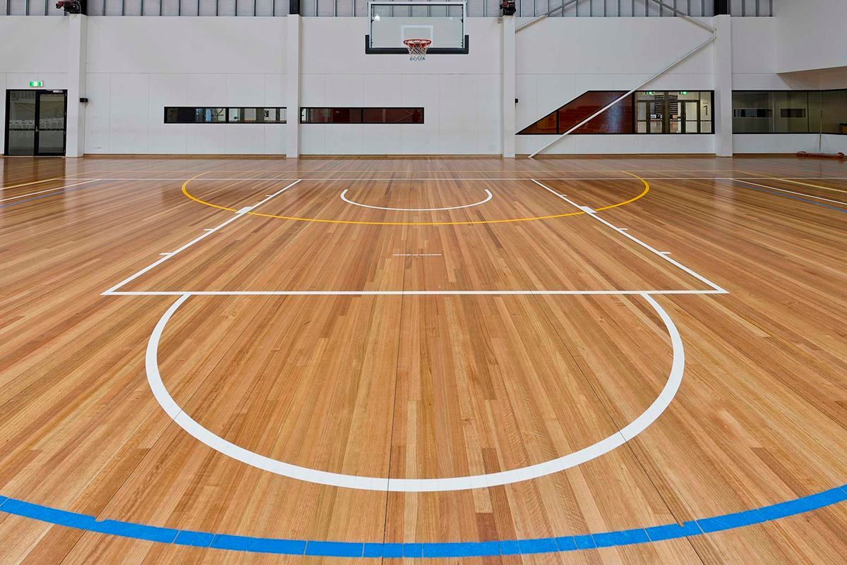 A basketball court with a wooden floor and a blue line