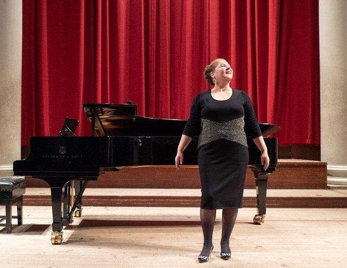 louisa behind a piano