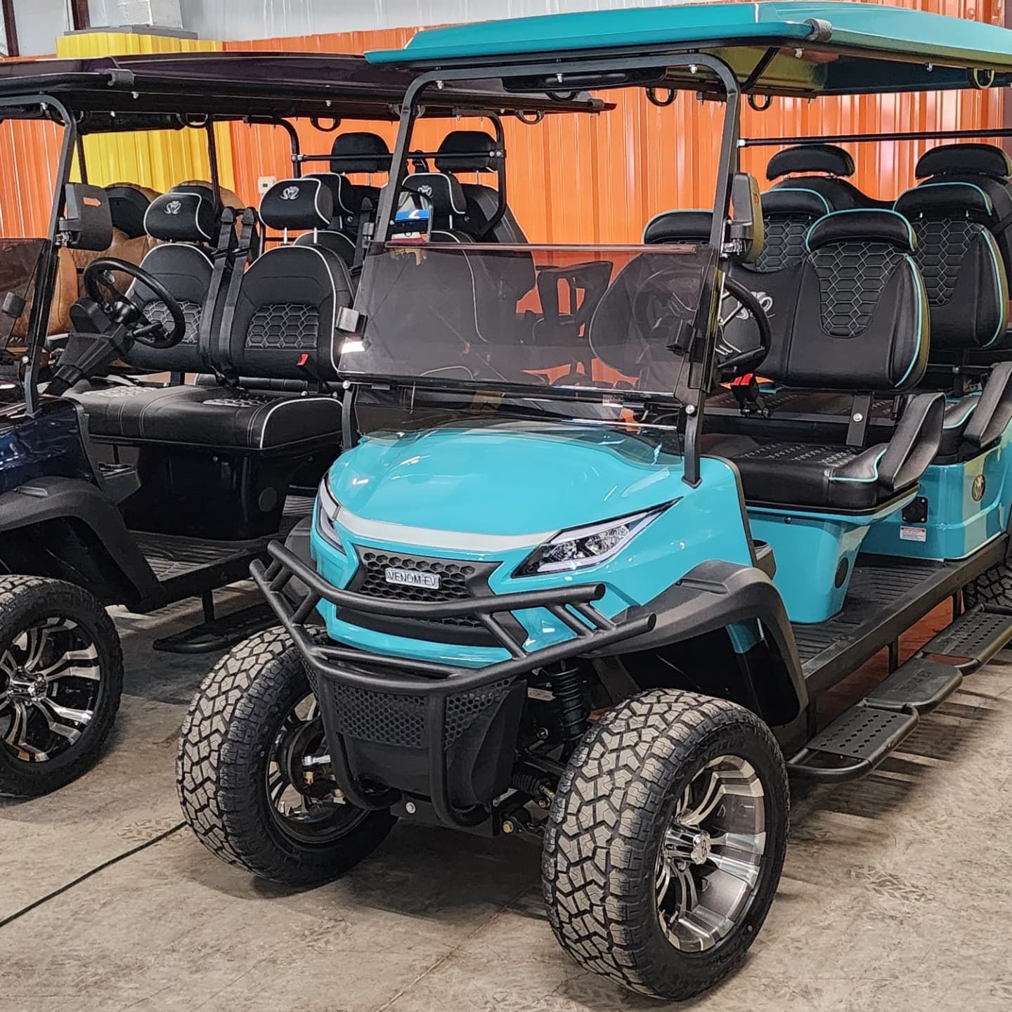 A row of golf carts are parked next to each other in a garage.