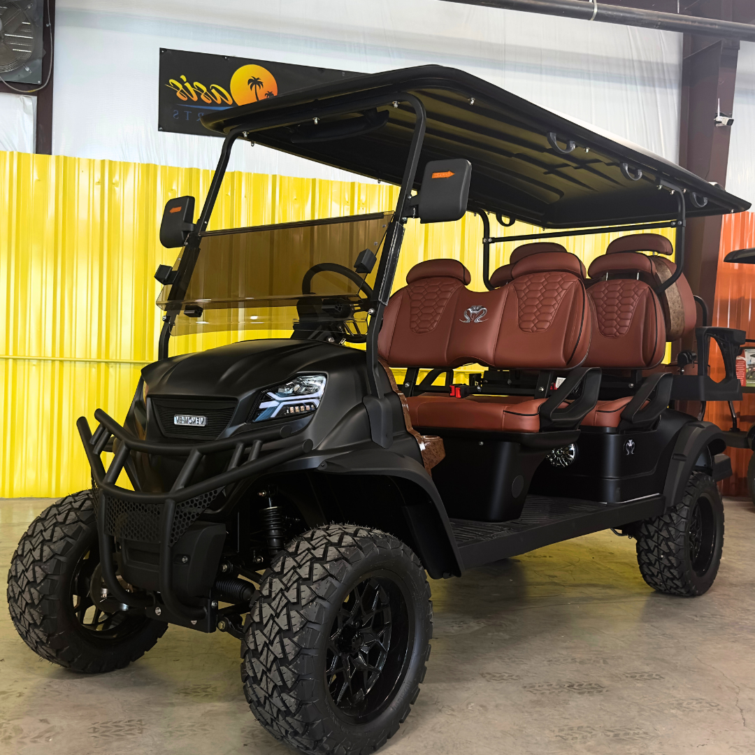 A black golf cart with red seats is parked in a garage.