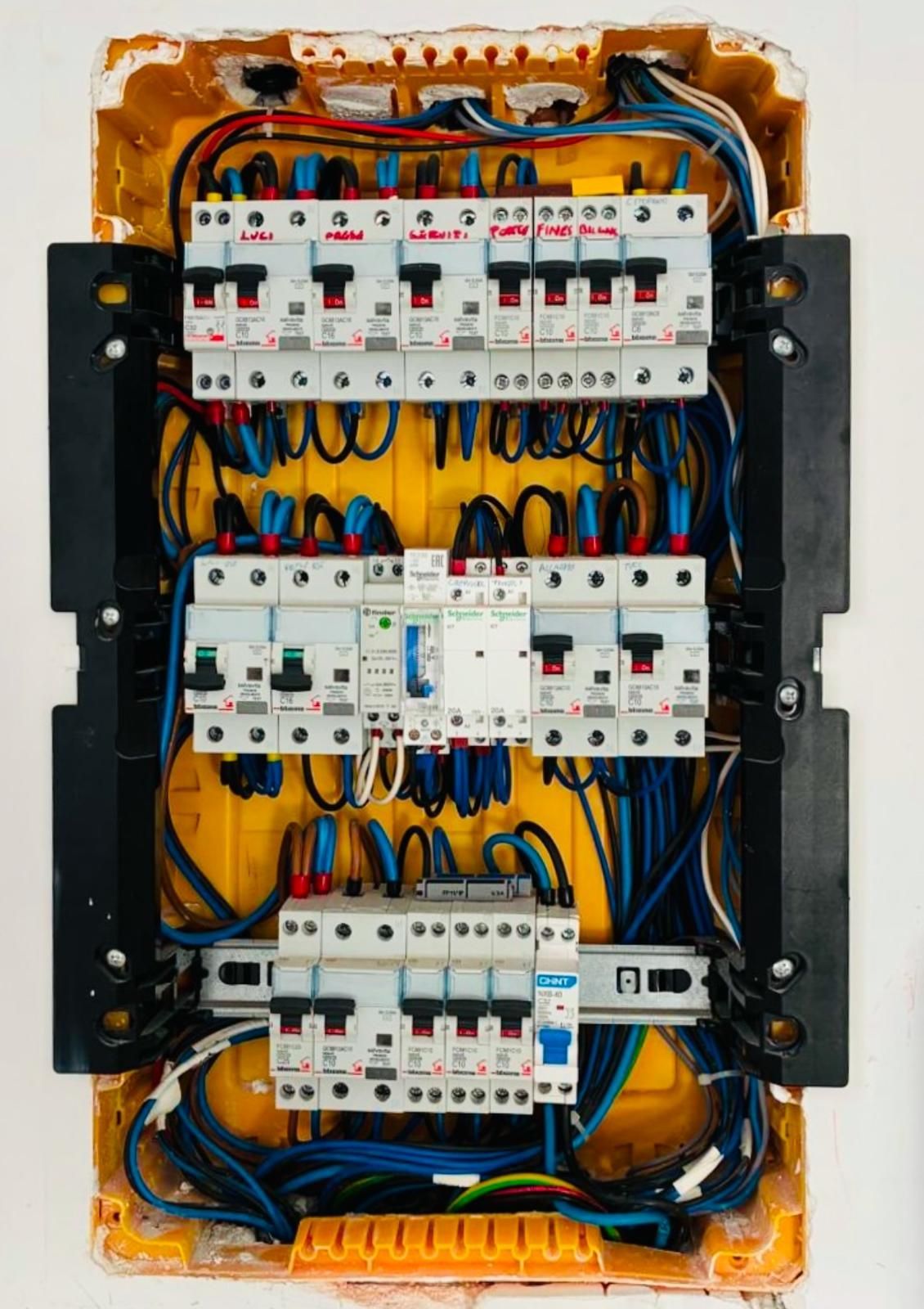 Scatola portafusibili elettrica con fili rossi e neri all'interno di un involucro bianco.