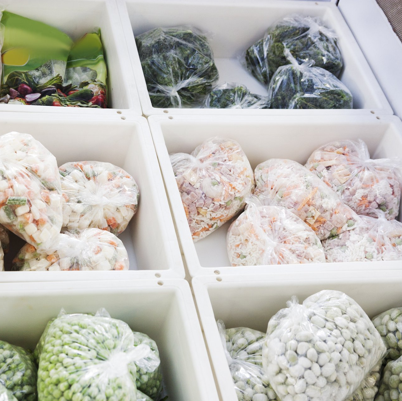 A variety of vegetables are displayed in plastic bags