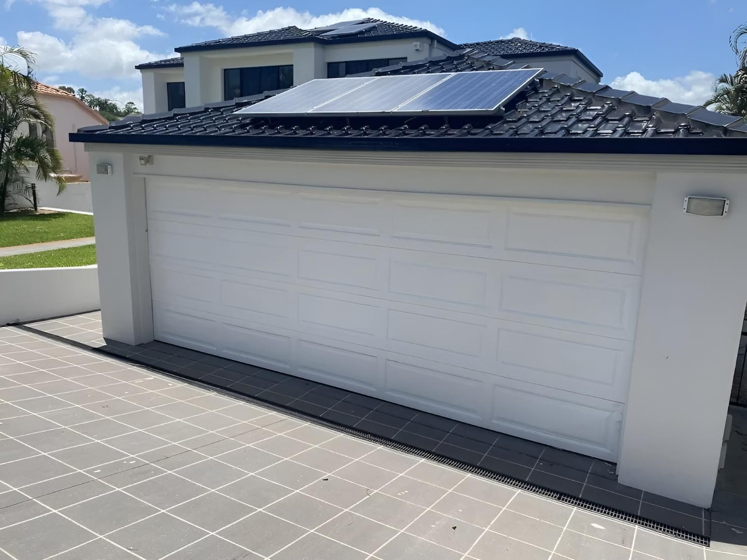 White Garage Door With a Solar Panel — Automated Garage Doors in Chuwar, QLD