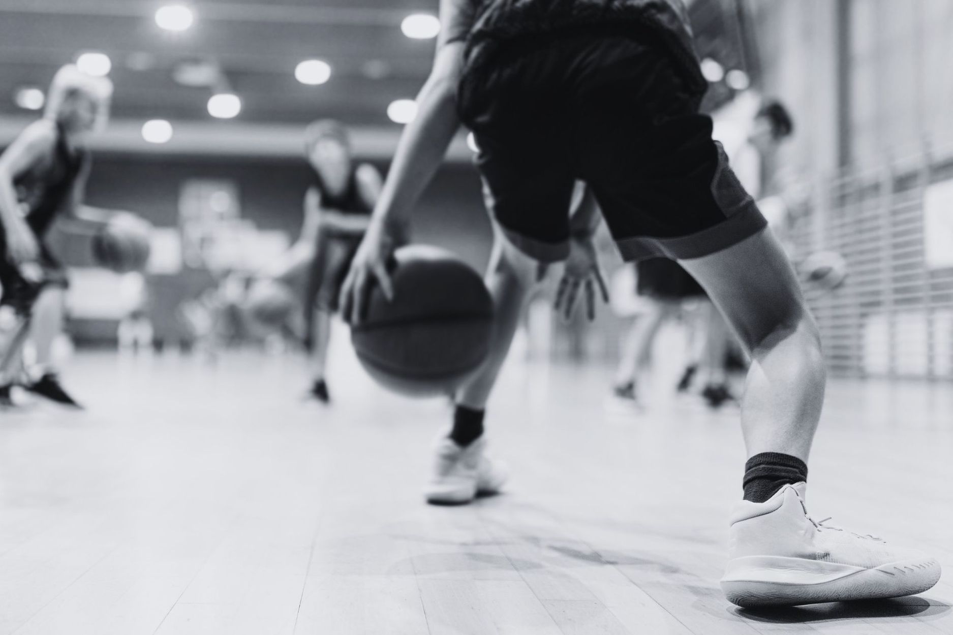 A group of young men are playing basketball on a court.
