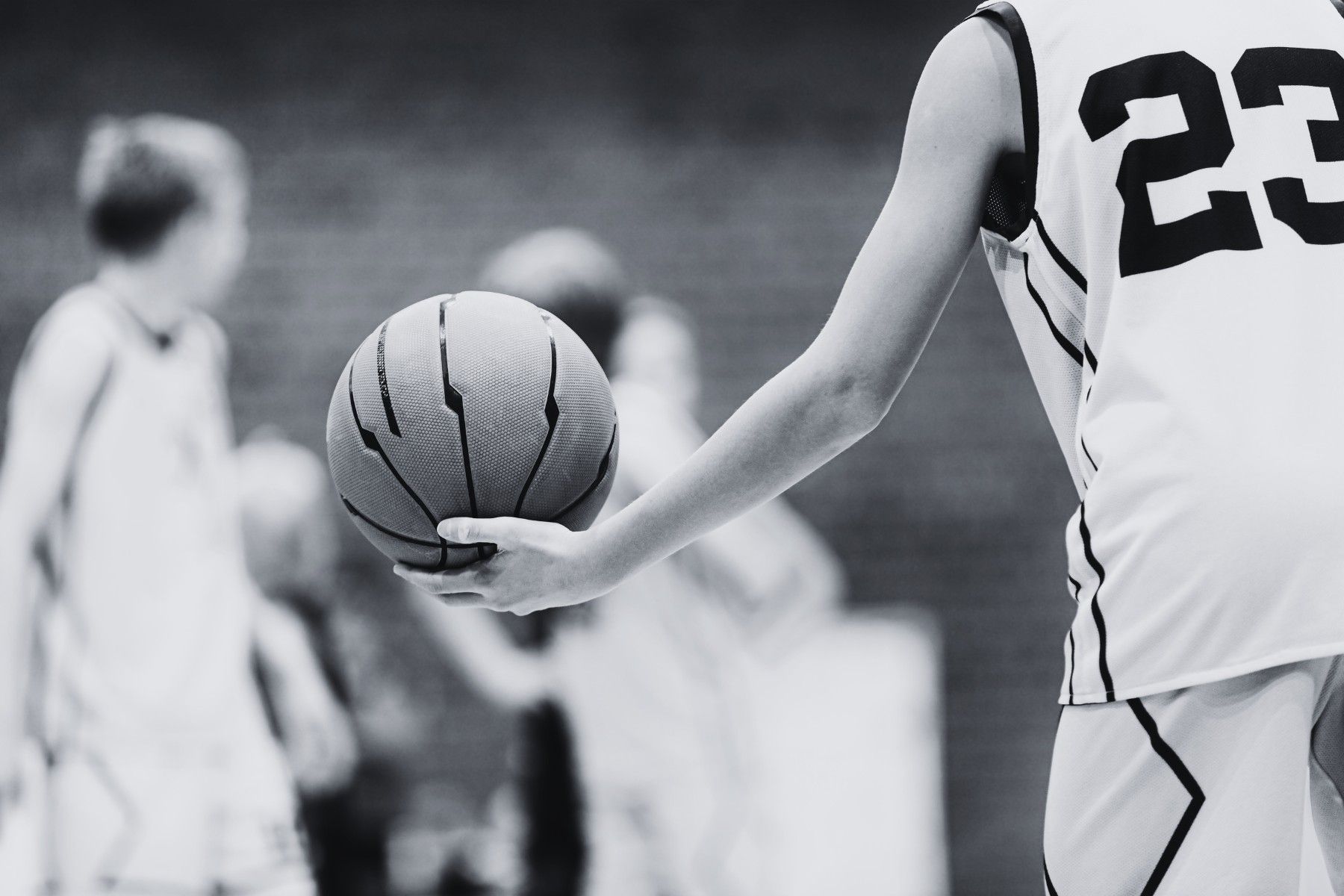 A black and white photo of a person holding a basketball.