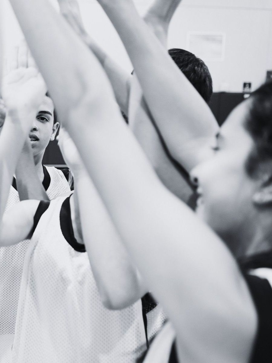 A black and white photo of a group of people with their arms in the air