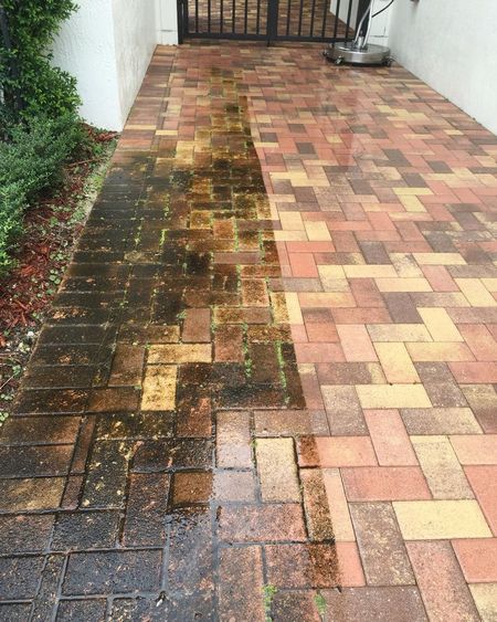 A brick walkway shows a side-by-side comparison of a dirty, mossy surface being power-washed into a clean, bright state.