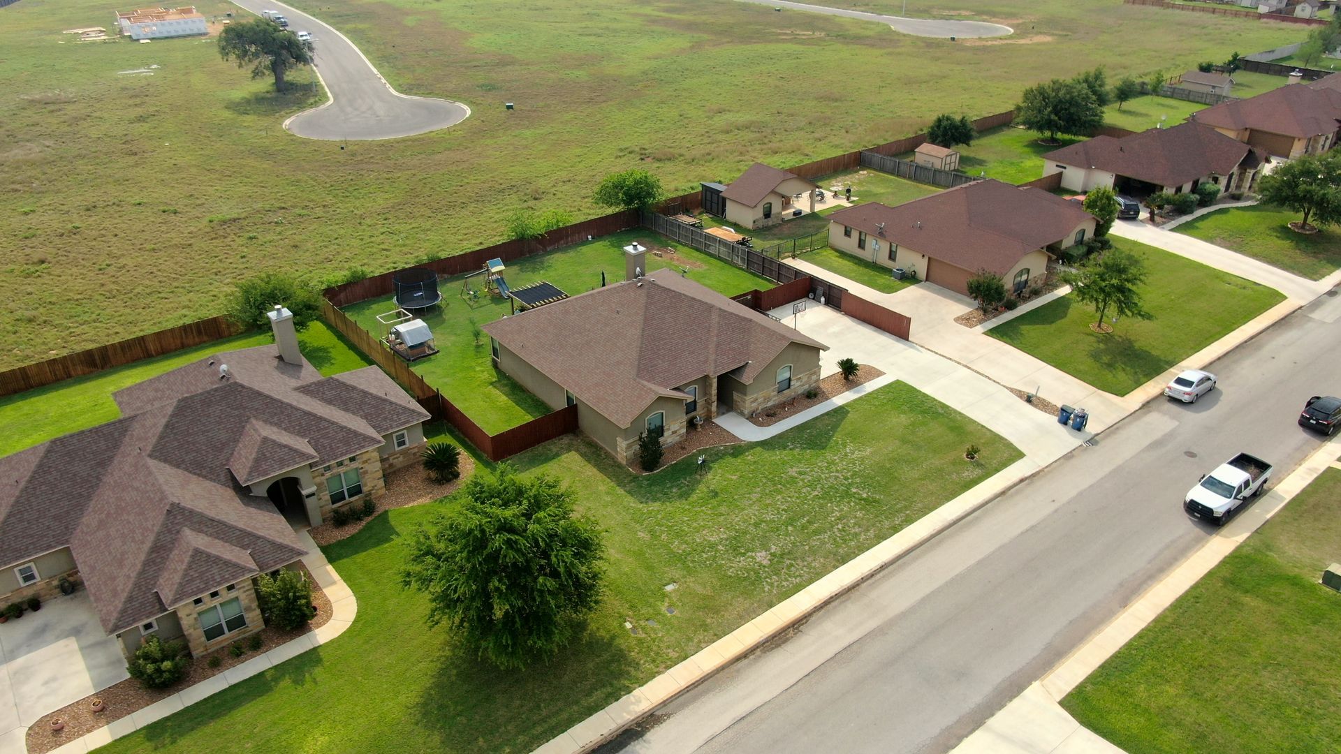 Several new construction homes on a street with nice lawns.