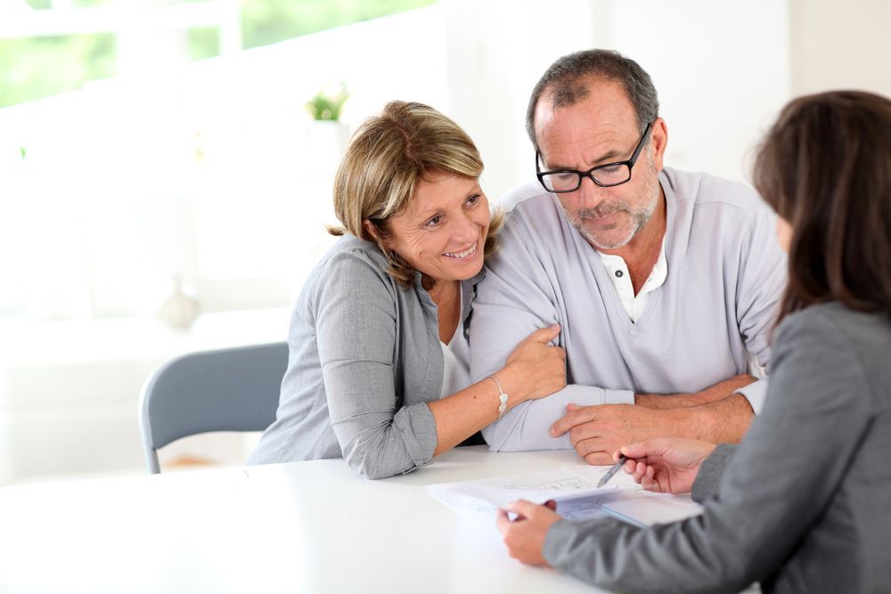 Couple Looking at Documents with A Person — Freedom Wealth Solutions in Mornington, VIC