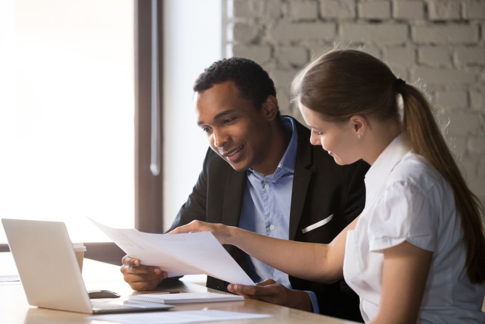 Man and Woman Reviewing Documents Together at A Desk — Freedom Wealth Solutions in Mornington, VIC