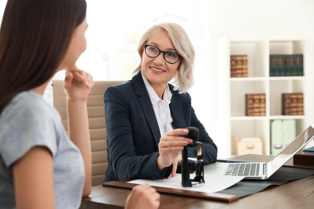 Woman Signing Document at A Desk — Freedom Wealth Solutions in Mornington, VIC