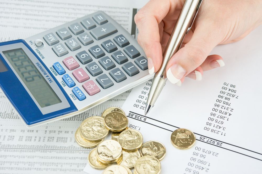 Person's Hand with Pen Calculating Finances on Paper — Freedom Wealth Solutions in Mornington, VIC
