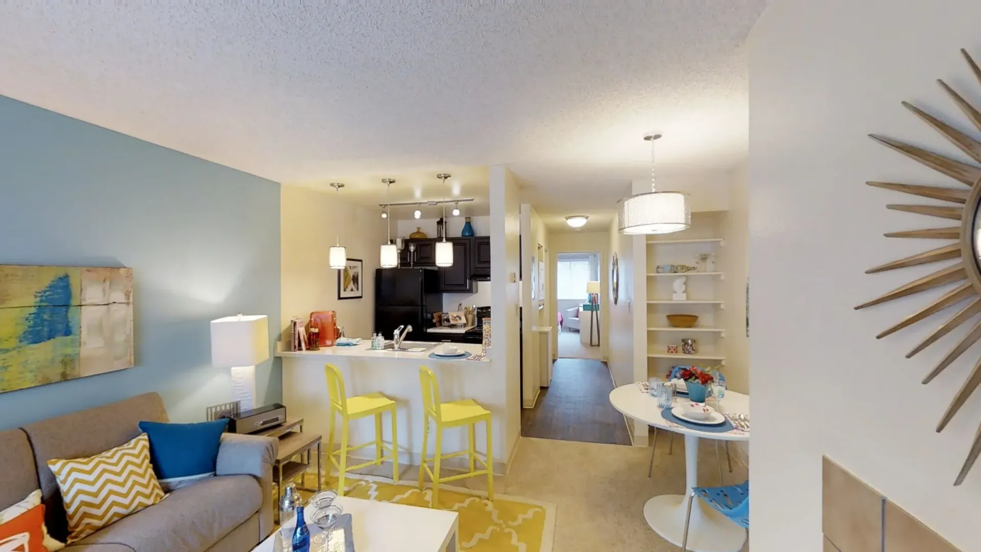 Living room and kitchen area with dining table and bar seating.