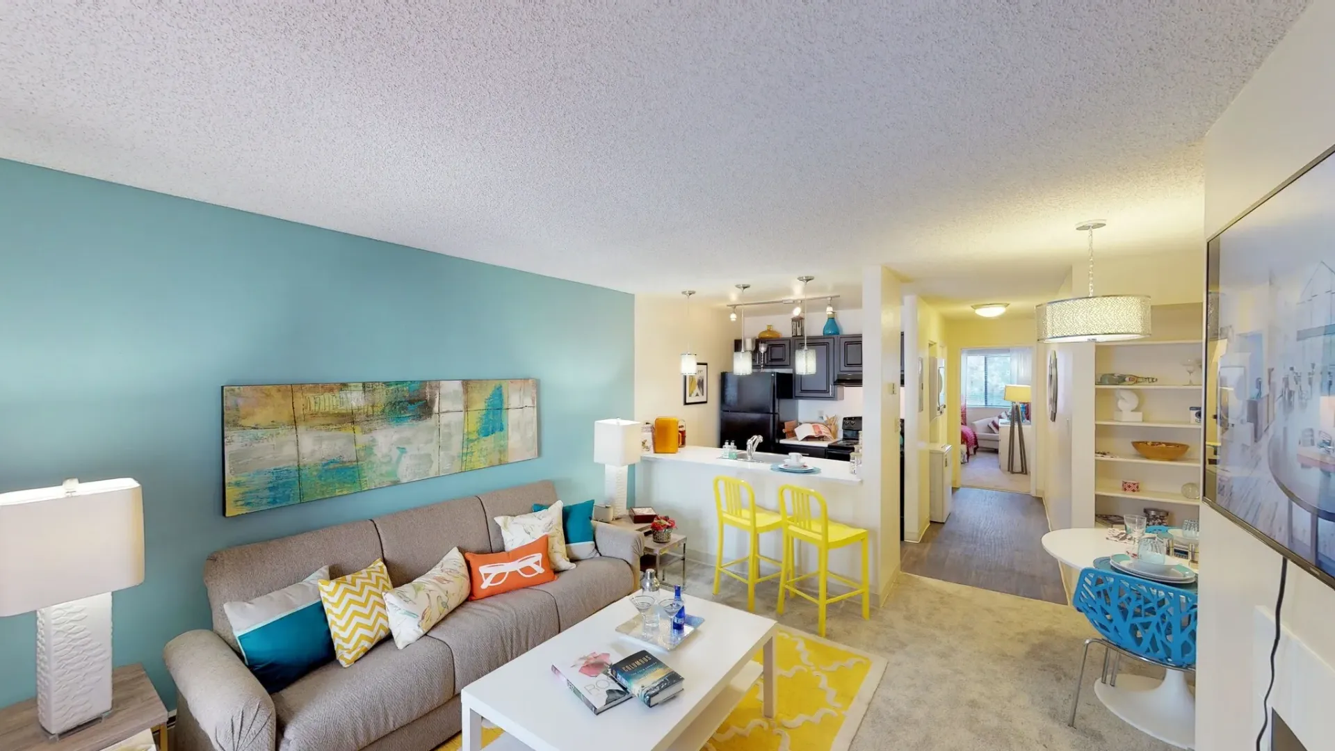 A spacious living room with a sofa, coffee table, and open kitchen.