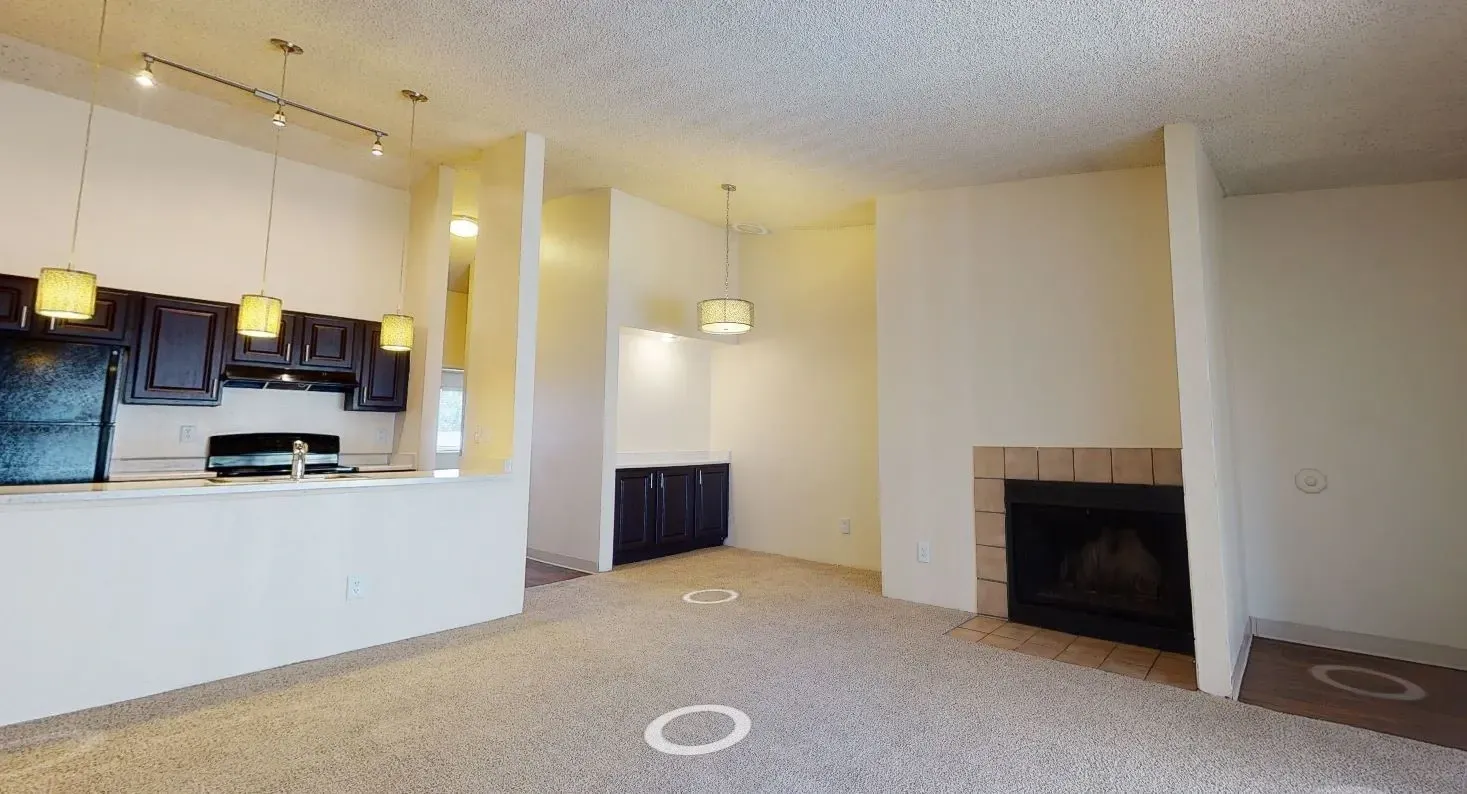 Living room with fireplace and adjacent kitchen area.