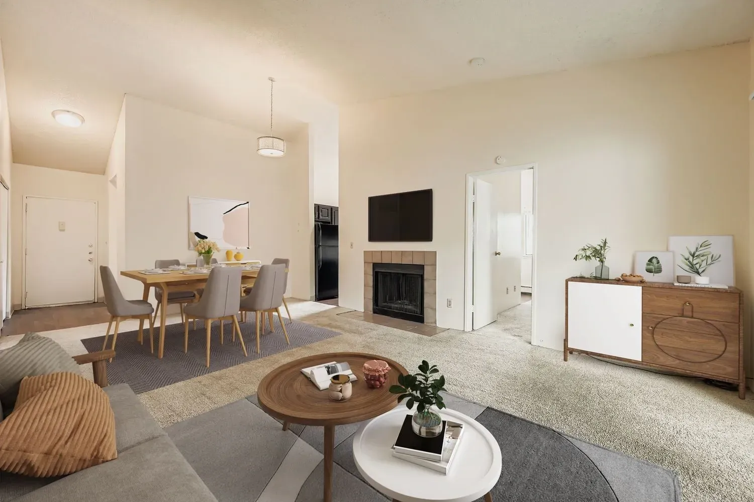 Living and dining area with fireplace and TV in an apartment.