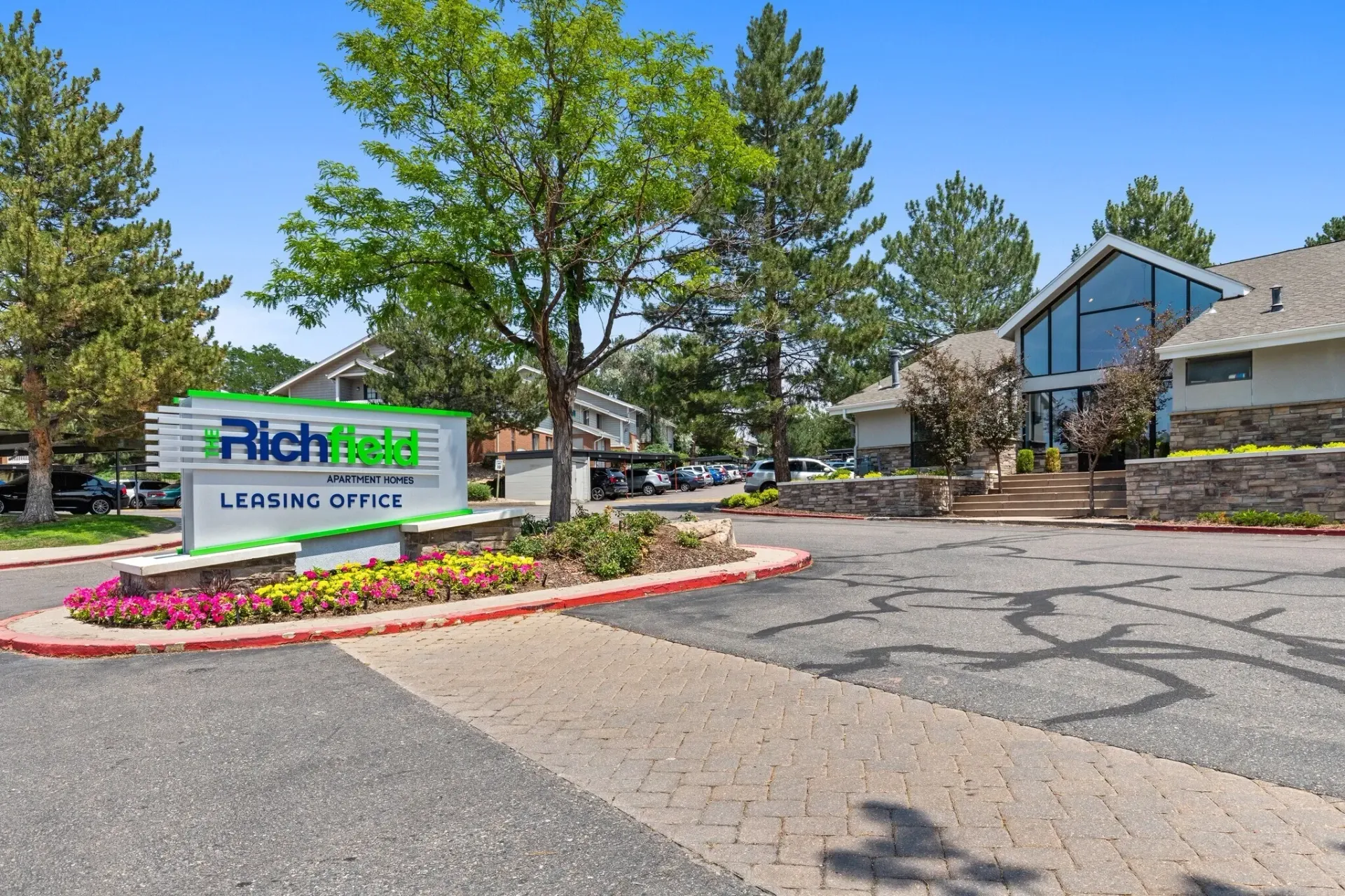 Richfield Apartment Homes leasing office sign with manicured flower beds.