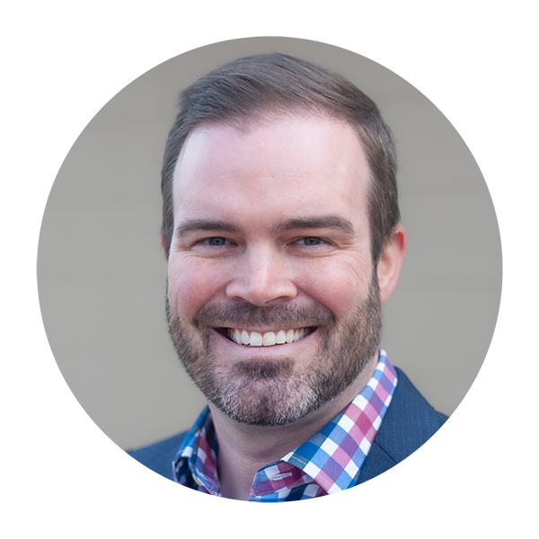 A man with a beard and collared shirt and sport coat is smiling in a circle