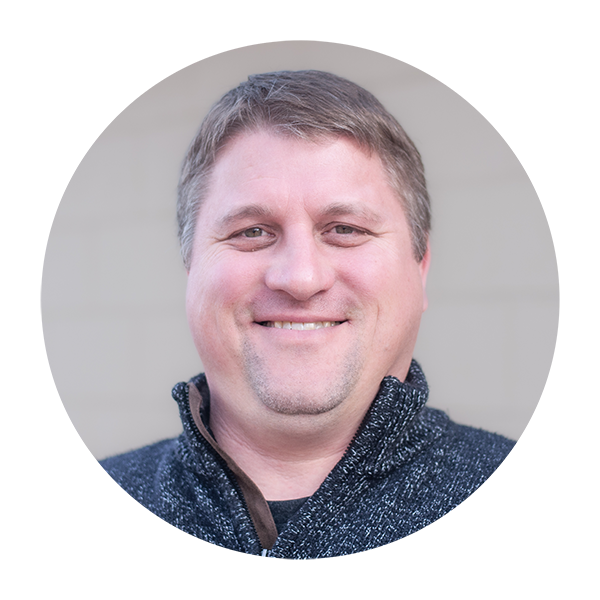 A man with a quarter zip shirt is smiling in a circle