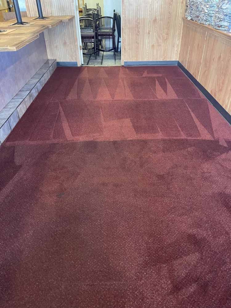 A room with a red carpet and a wooden wall.