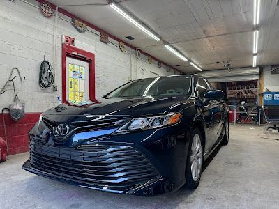 A black toyota camry is parked in a garage.