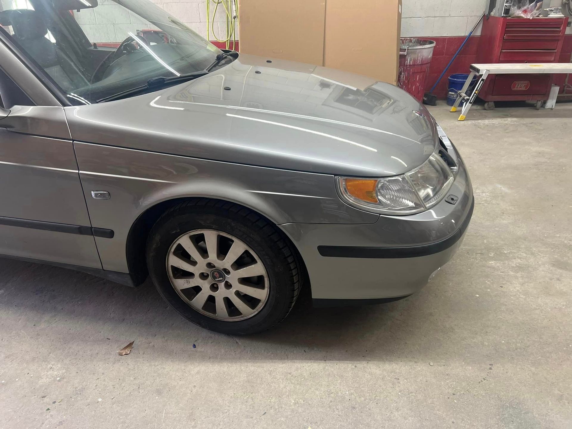 A silver car is parked in a garage.