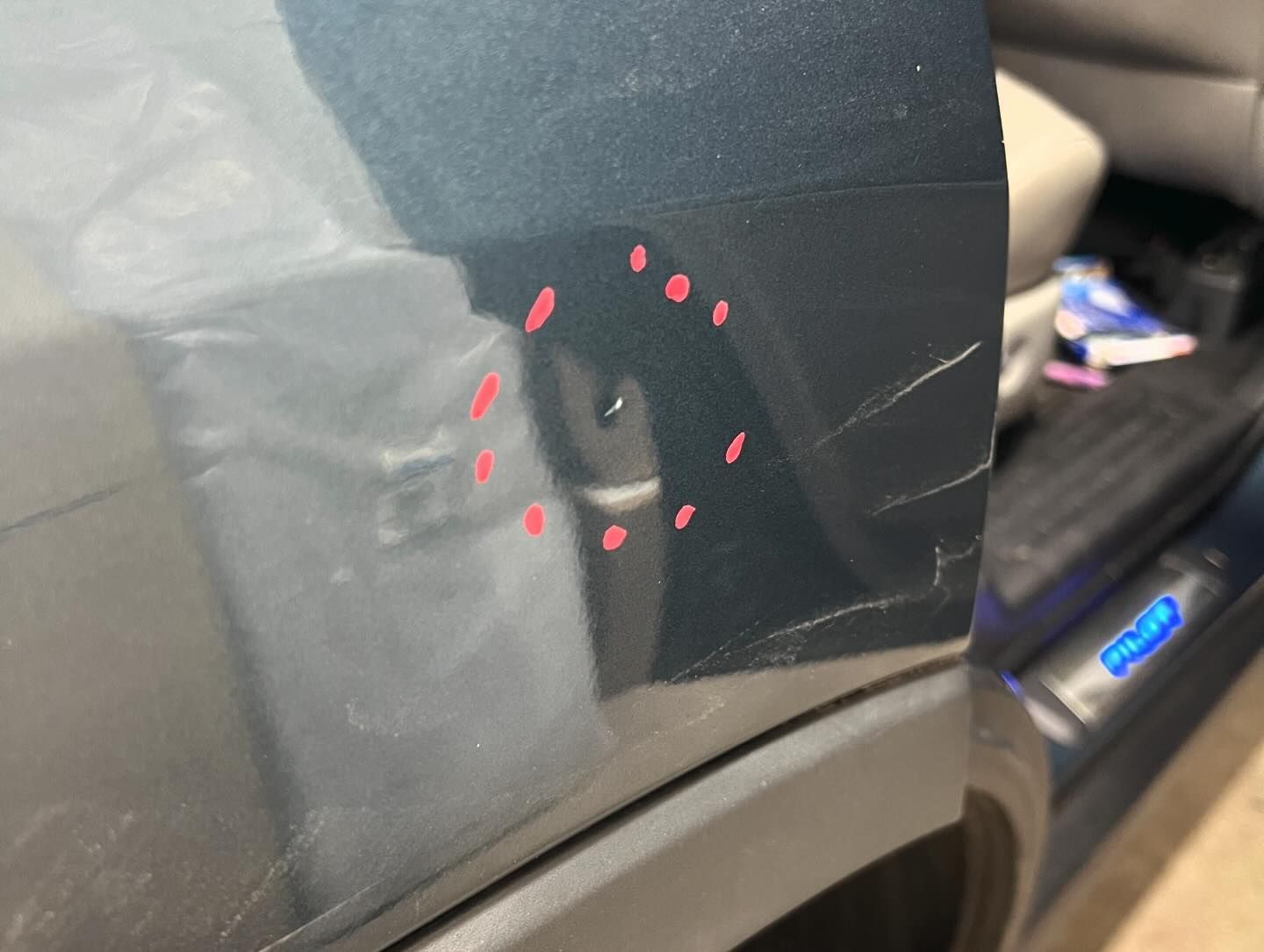 A close up of a scratch on the side of a car.