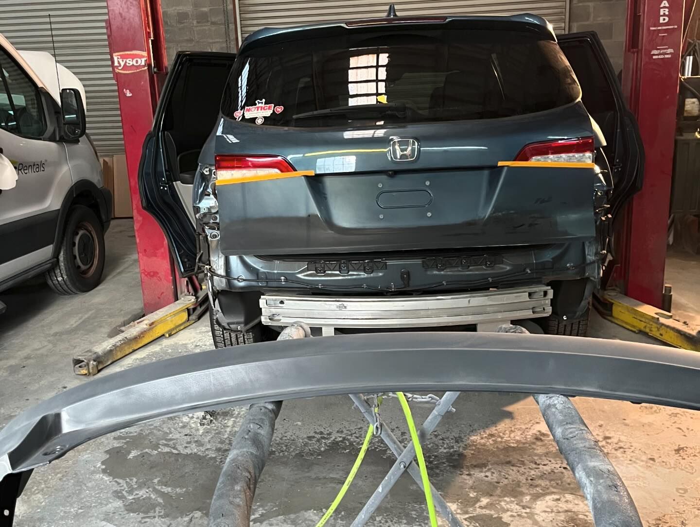 A car is sitting on a lift in a garage.