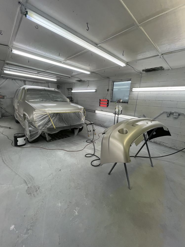A car is being painted in a paint booth.