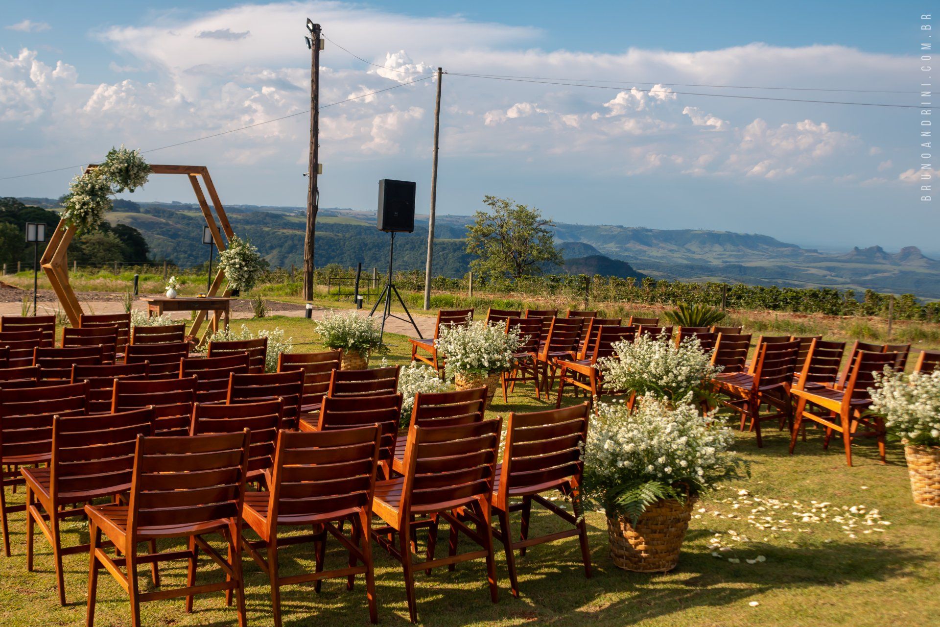 Decoração de casamento no alto da colina com móveis rústico e flores do campo.