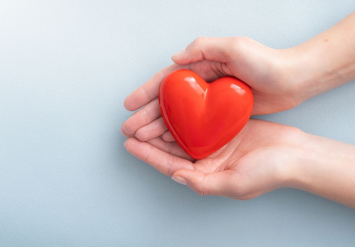Person holding an object shaped like a heart.