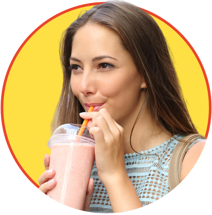 a woman drinking a pink smoothie with a straw