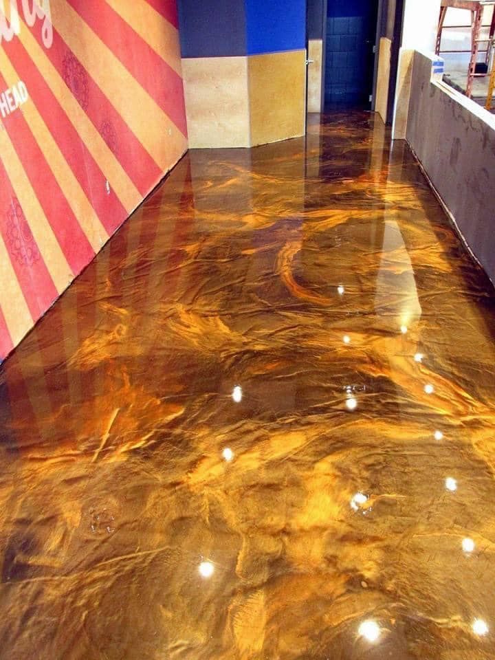 Gold and brown metallic epoxy floor with swirling patterns.
