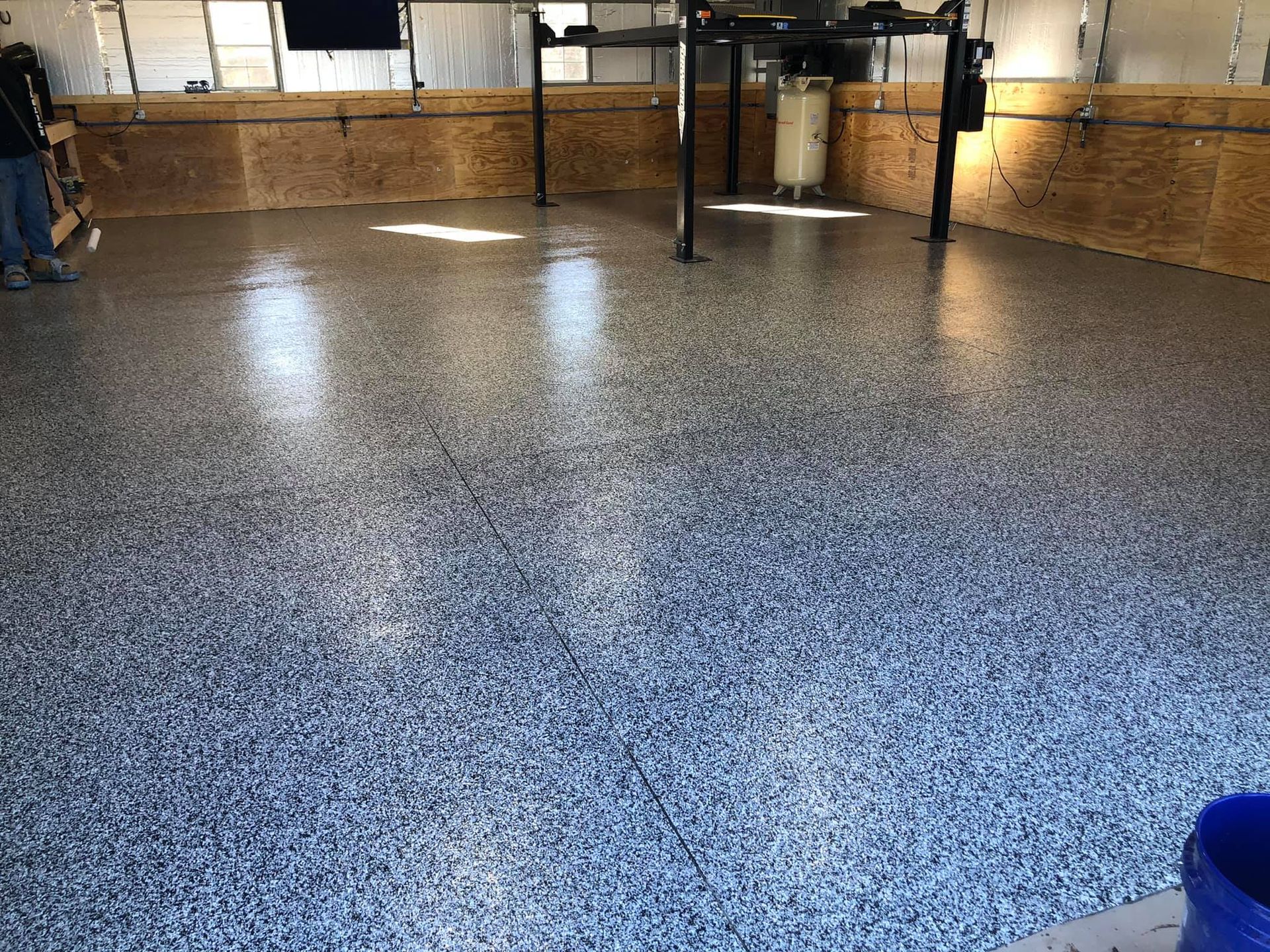 Garage floor with speckled blue and gray epoxy coating.