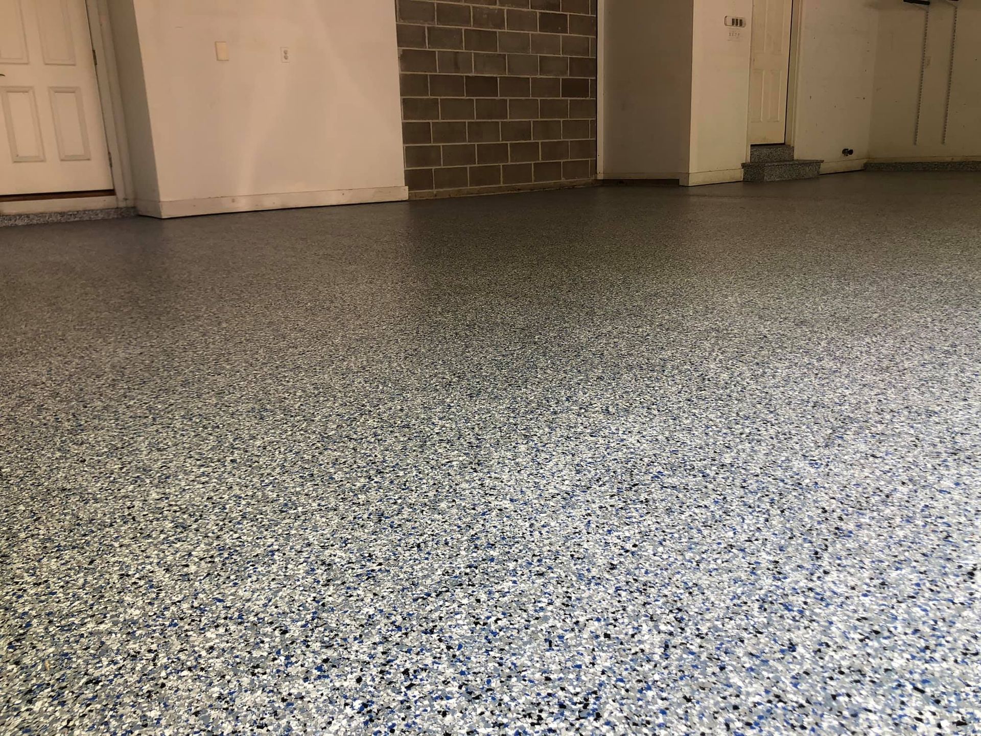 Garage floor with blue, gray, and white speckled epoxy coating.