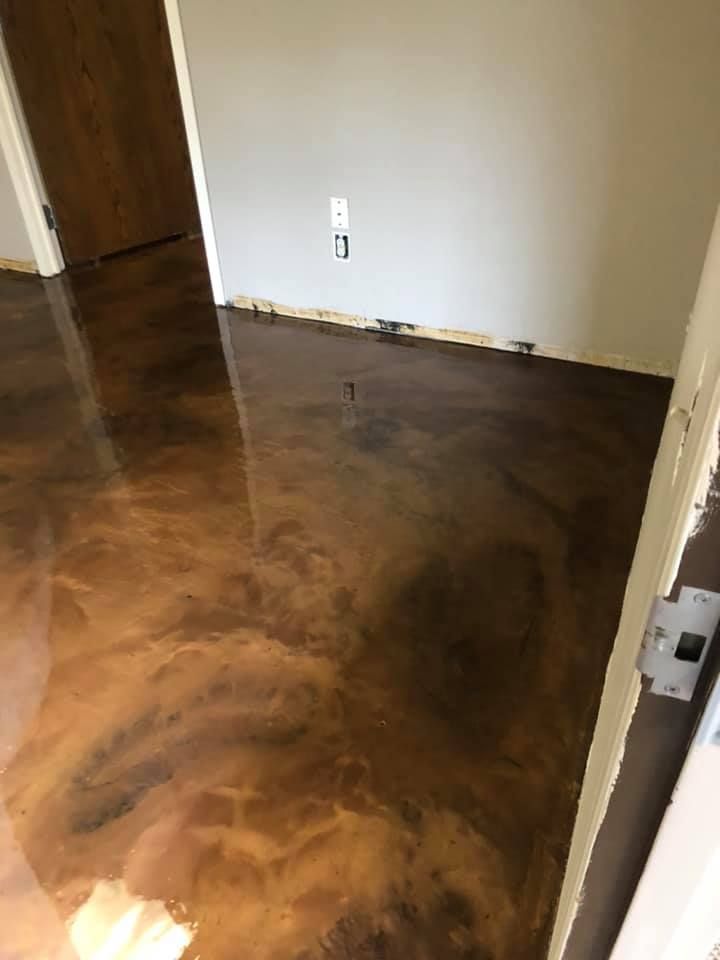 Metallic brown epoxy floor in a room, reflecting light. White walls and door frames.