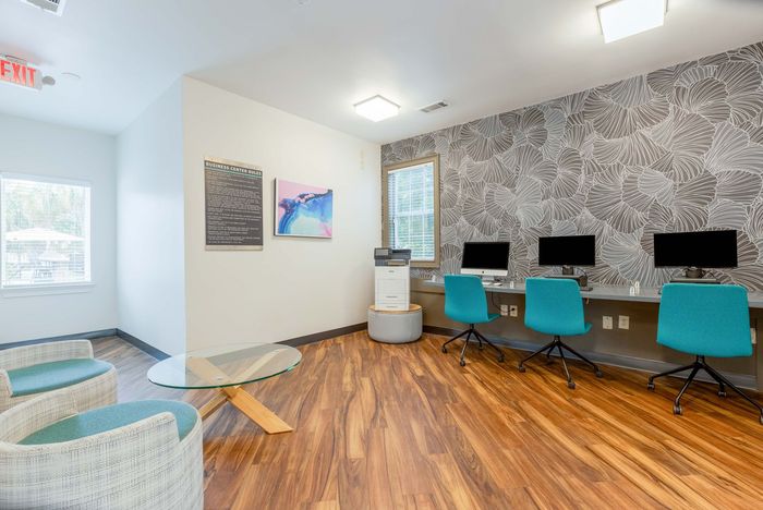 Computer lab with multiple computers and colorful chairs.