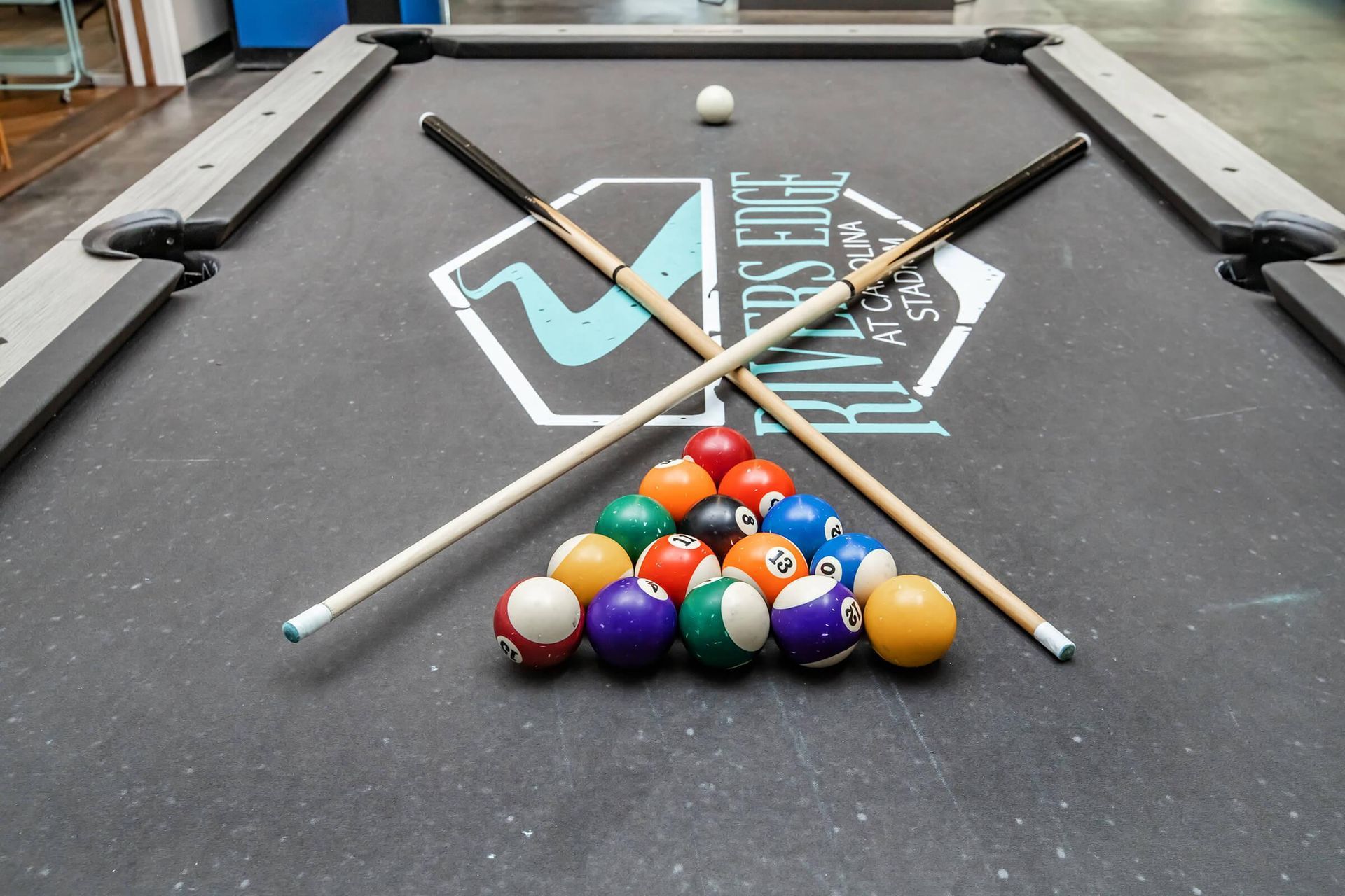 Pool balls and cues on a pool table at Rivers Edge at Carolina Stadium.